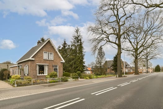 a street with houses and trees in the middle part of the photo is taken on a sunny, clear day