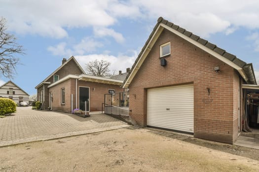 a brick house with two garages in the front and one on the other side that has a white door