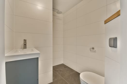 a bathroom with white tiles on the walls and gray tile around the shower stall, which has been used for several years