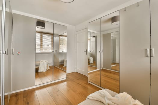 a modern bathroom with wood flooring and large mirrors on the wall in front of the bathtub is reflected in the mirror