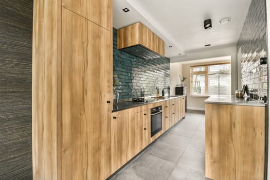 a modern kitchen with wood cabinets and black countertops on the wall, in an open plan area for cooking