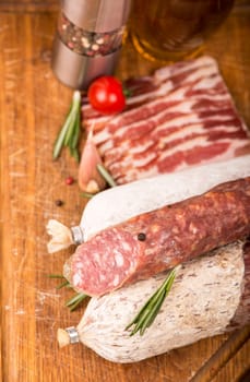 Smoked sausage with rosemary and peppercorns tomatoes and garlic close up