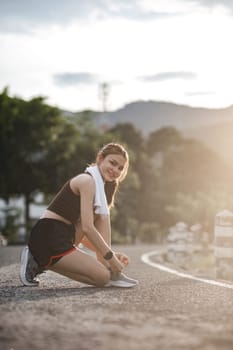 Portrait of a young woman tying her shoes to prepare for exercise..