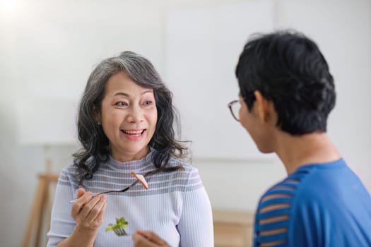 two 60s woman enjoys talking with her friends and having a healthy food together..