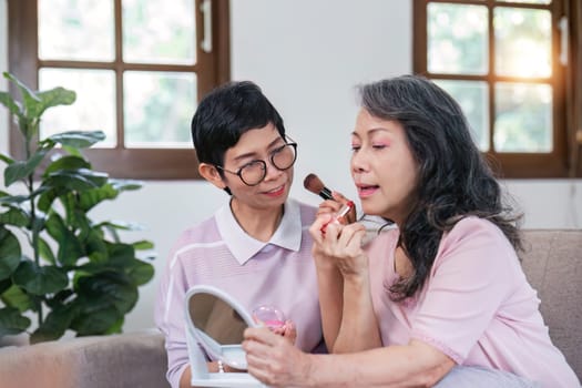 An elderly woman happily spends her free time make up with friends in the living room..