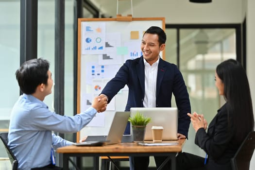 Confident male team leader shaking hands after successful meeting. Teamwork, success and support.