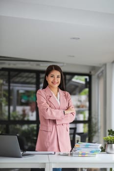 Portrait, Successful businesswoman leader in suit standing in office with arms crossed..