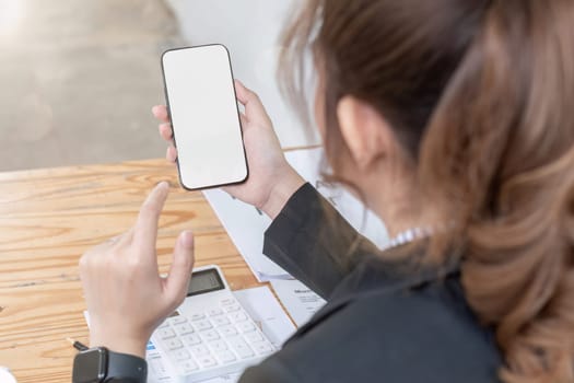 Woman holding phone showing white screen on top view while sitting in office.