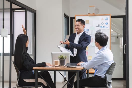 Professional businessman presenting to colleagues in conference room explaining growth chart.