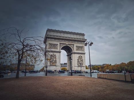 Arc de triomphe in Paris, France. Rainy autumn day with a romantic view to the triumphal arch landmark from avenue