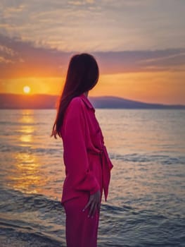 Portrait of a young woman as meets the dawn at the sea. Beautiful sunrise at the Bulgarian coastline of Black Sea, Sunny beach resort. Summer holiday background