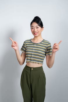 Beautiful young Asian woman pointing two side to copy space with smiley face and happy