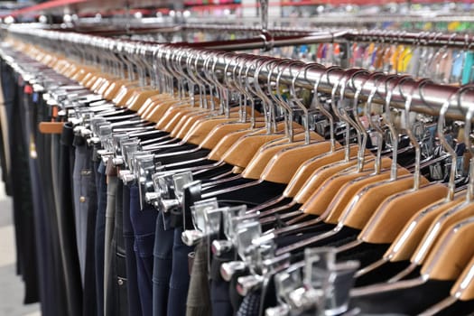 Men's trousers hang in row in a store