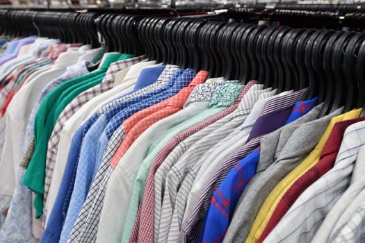 Cotton shirts hanging in a row in a store