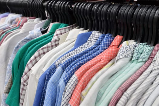 Cotton shirts hanging in a row in a store