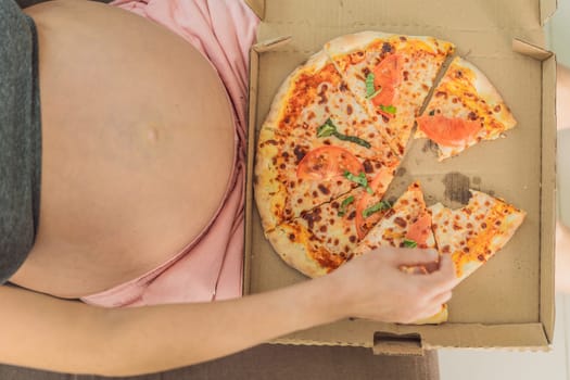 A pregnant woman enjoys a slice of pizza, savoring a moment of indulgence while satisfying her craving for a delightful, comforting treat. Excited Pregnant Young Lady Enjoying Pizza Holding Biting Tasty Slice Posing With Carton Box. Junk Food Lover Eating Italian Pizza. Unhealthy Nutrition Cheat Meal.