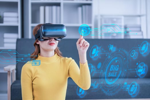 Attractive Asian woman shopping for online discount campaign in virtual reality through VR glasses on the sofa having fun and entertainment time in your home living room..