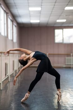 Asian woman dancing in ballet class. Bending in the back