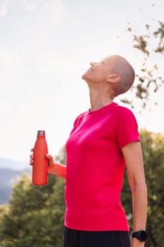 woman drinking water during her training, concept of sport in nature and healthy lifestyle, copy space for text