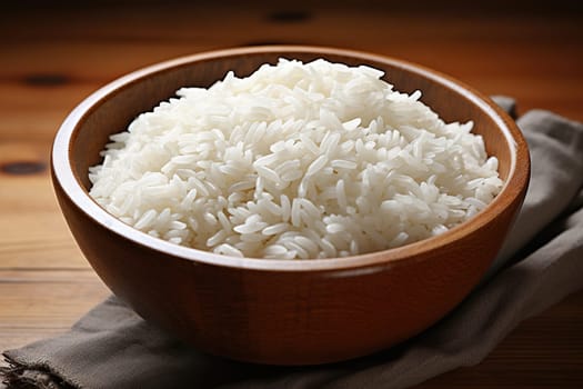 White cooked rice in a brown wooden bowl on a wooden table