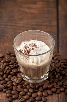 Hot espresso con panna in glass cup on wooden table