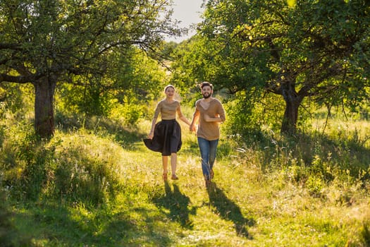 young couple walking in nature at sunset