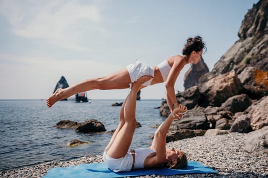 Woman sea yoga. Back view of free calm happy satisfied woman with long hair standing on top rock with yoga position against of sky by the sea. Healthy lifestyle outdoors in nature, fitness concept.