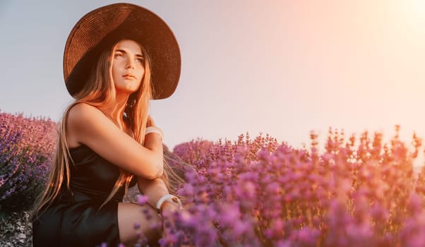 Close up portrait of young beautiful woman in a white dress and a hat is walking in the lavender field and smelling lavender bouquet.