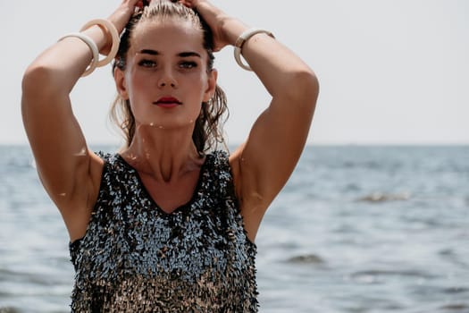 Woman travel sea. Young Happy woman in a long red dress posing on a beach near the sea on background of volcanic rocks, like in Iceland, sharing travel adventure journey