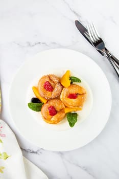 muffins with peach, raspberry, black berry and mint covered with powdered sugar