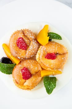 muffins with peach, raspberry, black berry and mint covered with powdered sugar