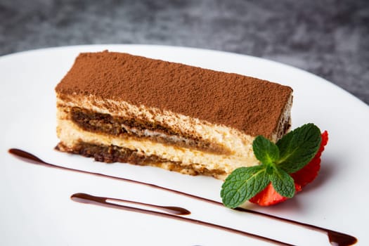 chocolate sponge cake with strawberries and mint on a white plate