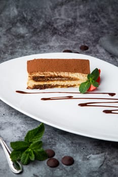 chocolate sponge cake with strawberries and mint on a white plate