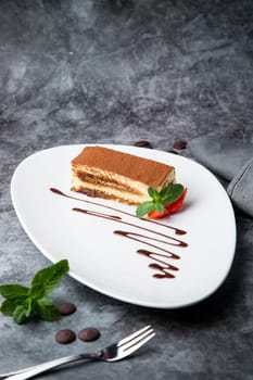 chocolate sponge cake with strawberries and mint on a white plate