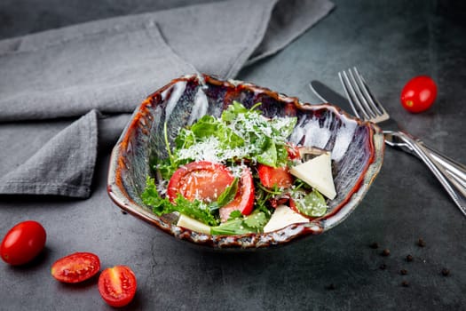 salad with herbs, tomatoes, grated cheese, sesame seeds and pieces of cheese