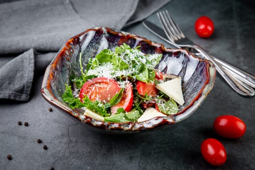 salad with herbs, tomatoes, grated cheese, sesame seeds and pieces of cheese