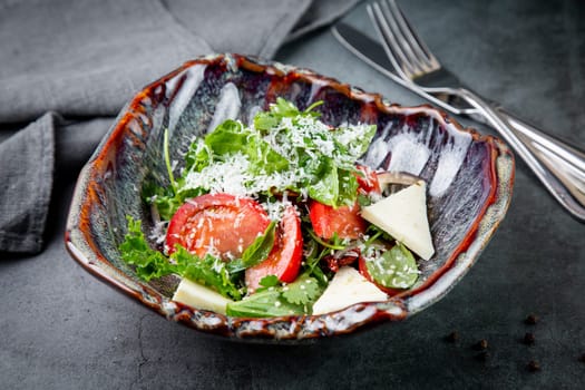 salad with herbs, tomatoes, grated cheese, sesame seeds and pieces of cheese