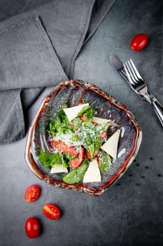 salad with herbs, tomatoes, grated cheese, sesame seeds and pieces of cheese