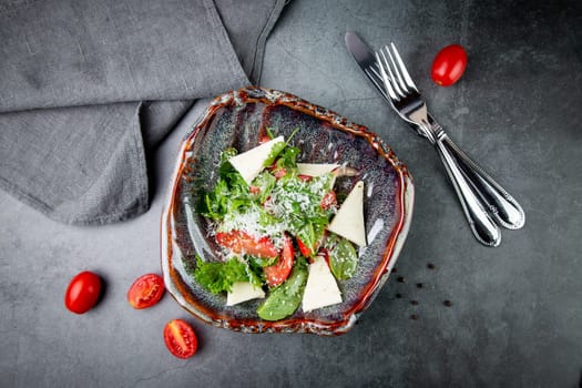 salad with herbs, tomatoes, grated cheese, sesame seeds and pieces of cheese