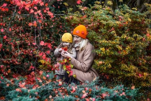 Mother and daughter in autumn in a beautiful autumn park