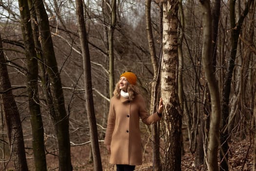 Woman in a brown coat in the forest