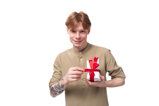 young handsome redhead man in glasses and shirt holding birthday gift box.
