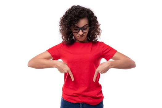 a young well-groomed woman in glasses for vision is dressed in a red basic T-shirt actively gesturing pointing with her hands.