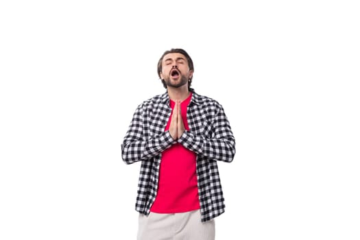 young smart brunette caucasian man with a beard in a plaid shirt on a white background.