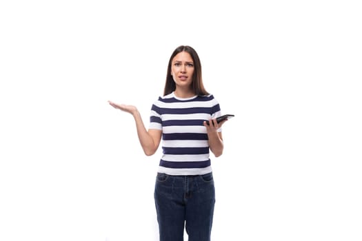 charming young european woman with black straight hair in a striped black and white t-shirt and jeans doubts spreading her arms.