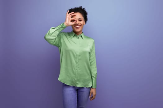 young bright cheerful latin woman dressed in a green blouse on the background with copy space.