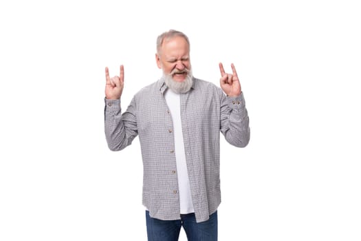 handsome gray-haired elderly man in a shirt shows with his hands that he is cool on a white background with copy space.