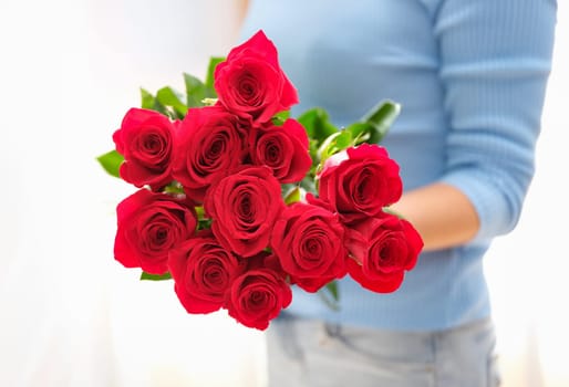 Woman is holding bouquet of beautiful red roses. Pleasant surprises for women concept
