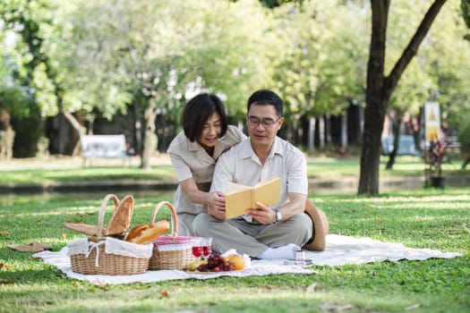 Senior couple picnicking in the park showing their love, support or reconnecting after retirement in a relaxed park. And elderly men and women happily sit on mats in the backyard to rest..