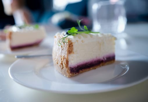 Piece of delicious cottage cheese cake with jam on plate. Sweet calorie cake concept